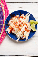 Mexican jicama  cutted with chili powder and piquant sauce on white background