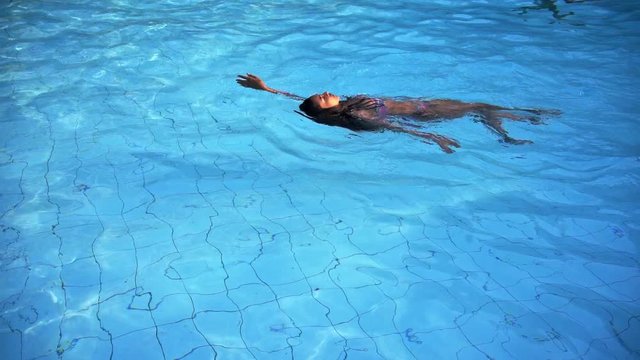 Asian woman relaxing in swimming pool at luxury hotel spa enjoying   travel holiday resort. 4k footage.