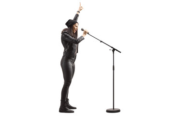 Female singer in black leather pants singing on a microphone
