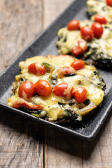 Portobello stuffed with spinach and cheese on wooden background