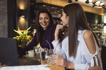 Mother and daughter enjoying a drink at a coffee restaurant