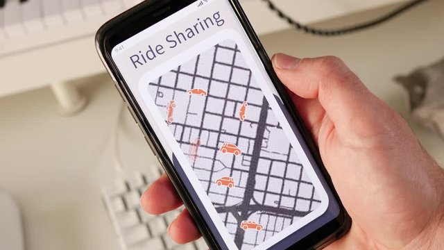 Looking at the interactive map of a ride-sharing app showing different vehicles driving around the city.