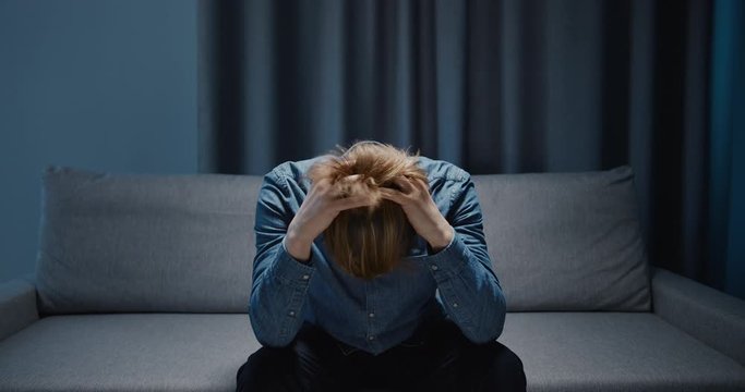 Lonely depressed male suffering mental breakdown, siting in dark room, depression