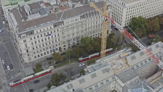 Aerial view of buildings in vienna skyline with a construction area and cranes. trams crossing the picture