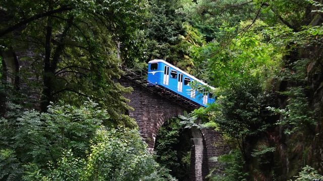 Funicular railcar train to Madonna del Sasso, above Lake Maggiore.  Locarno, Ticino. Swiss Alps. Switzerland summer tourism. Slow motion.
