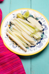 Mexican jicama and cucumber cutted on turquoise background