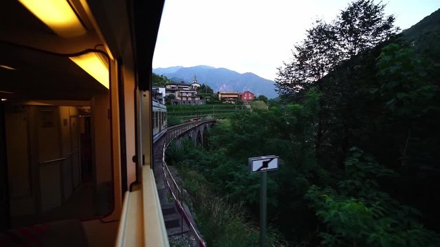 Scenic Centovalli Railway Locarno to Domodossola train on famous bridge. Swiss Alps. Slow motion. Ticino, Switzerland summer tourism.