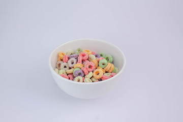 Fruit cereal in white cup on white table
