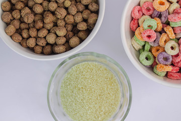 Fruit and chocolate cereal on white table next to small cup of sugar