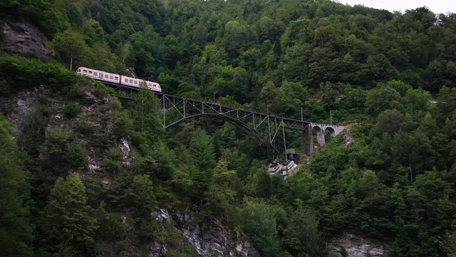 Scenic swiss train Centovalli Railway Locarno-Domodossola on bridge. Intragna village. Swiss Alps. Ticino Switzerland in summer, 4k. 