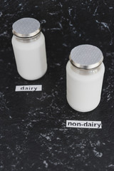 bottles of milk with Dairy and non-dairy labels in front of them