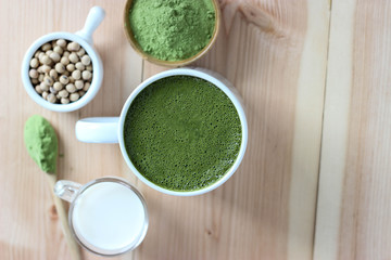 Fototapeta na wymiar Top view,Closes up Hot Green Tea Matcha Latte. Decorate with powder extract and soy beans, milk.