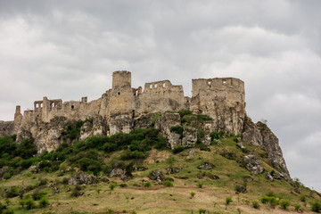 Fototapeta na wymiar ruins of spis castle on a cloudy day in springtime. famous travel destination of slovakia. UNESCO heritage. grassy meadow at the foot of the hill.