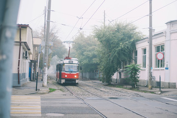 Historic red tram in the fog on the street in the moning