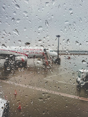 Closeup toned photo of the airport and airplanes during heavy rain