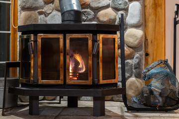 Plakat Wood stove fireplace with metal body and glass door in house with cozy interior