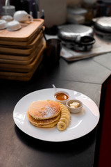 pancakes breakfast with bananas on white dish