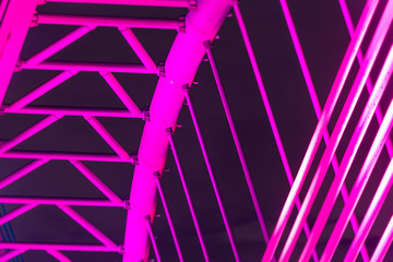 The illuminated structure of the Seri Saujana Bridge at night. One of many bridges in Putrajaya, Malaysia, all alternately illuminated in unison in different colors. Putrajaya Bridge Malaysia at night