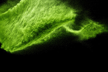 Green dust particles explosion on black background. Powder dust splash.