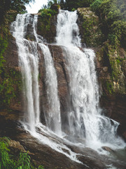 Toned photo of beautiful waterfall cascade in the mountains of tropical asian island