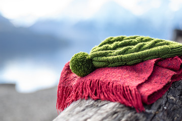 HAT AND SCARF SUPPORTED ON A TRUNK WITH A LAKE ON THE BACKGROUND