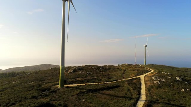 Wind power turbines aerial view. Windmill turbine generating clean renewable energy in green agricultural field aerial landscape. Wind energy station. Ecology and nature conservation in barizo, Spain