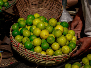 Green yellow lemon kept in basket in vegetable market i