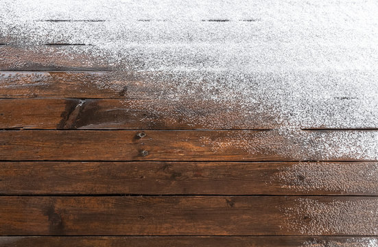 Snow on a wooden plank floor of an open terrace close-up as a background.