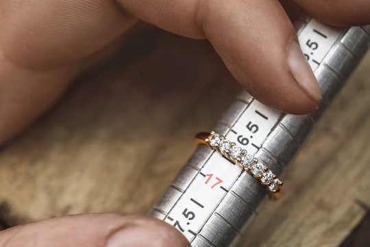 Jeweler checks the size of the gold ring, close-up