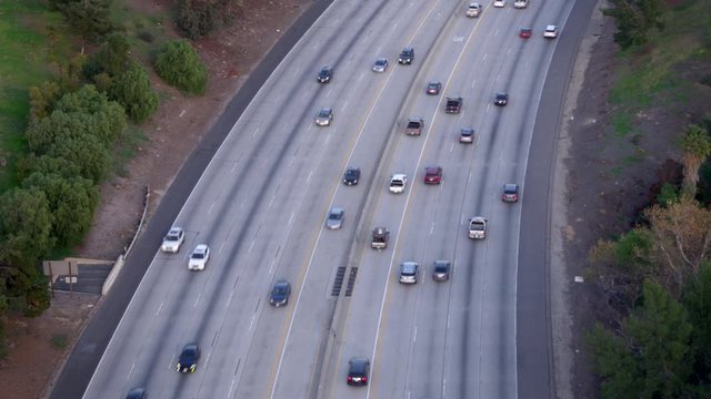 Aerial, tracking, drone shot, over traffic on a freeway, on a sunny evening, in Los Angeles, California, USA