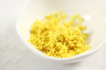 Shredded lemon rind in bowl. Making Lemon Mascarpone Pie Series.