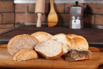 Assortment of sliced bread rolls at rural kitchen background