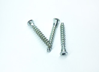 Self-tapping bolts with flat heads on a white background. A bunch of screws for twisting the hexagon. Construction.