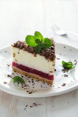 Slice of cheesecake with jam and chocolate flakes
