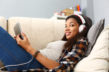 Black ordinary female american teen portrait at home sofa remote education concept. Girl hold...