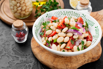 White bean salad with cherry tomatoes, red onion and parsley.