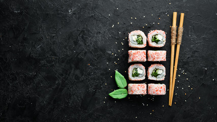 Japanese sushi with crab sticks, cheese, onion and cucumber. Asian Diet Food. Top view. © Yaruniv-Studio