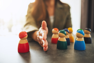 Concept image of a business woman separate one wooden people from a group