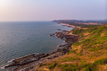 Aerial view of a rocky seashore during sunset
