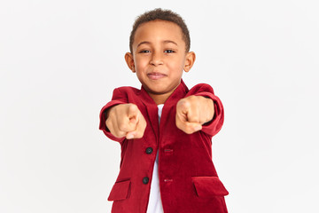 Studio shot of handsome energetic little Afro American pupil dressed in violet velvet jacket...