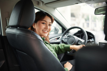 Fototapeta na wymiar Smiling woman sitting in a car and looking back