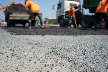 Blur image, repairing pavement mainly by manual labor