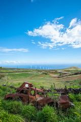 Fototapeta na wymiar wind turbines under blue sky on rolling hills by blue ocean , renewal energy