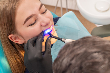 doctor illuminates the patient teeth
