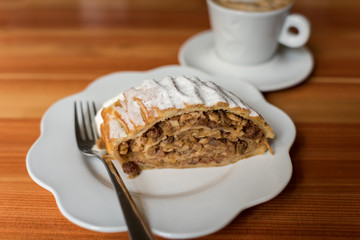 Walnut apple strudel dessert on white plate