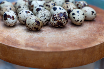 Fototapeta premium Quail eggs on a wooden board with side view