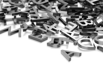 Heap of metal alphabetic character letters over white background, literature, education, know-how or writing concept, selective focus