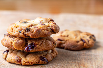 homemade cookies with cranberries and chocolate  on a wooden cutting board