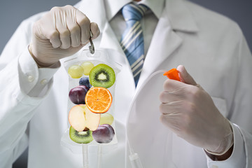 Doctor Holding Saline Bag With Fruit Slices Inside In Hospital