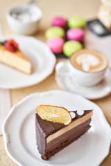 Chocolate sponge cake, with mousse, decorated with Orange slice and meringue. Breakfast in the cafe, morning coffee. on wooden table.